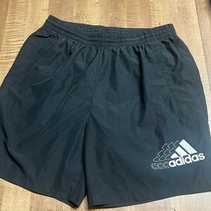 Adidas Large men’s shorts. 100%polyester, sits right above the knee (I’m 6’1”)
